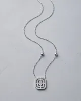 Collar de acero con dije rectangular geométrico recubierto de circonias y cadena fina con cuentas esféricas.