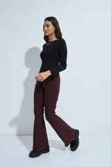 Pantalón de corte oxford, color negro, con ajuste en la cadera y pierna acampanada hacia el bajo. Presenta una silueta fluida y entallada.