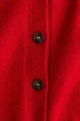 Saco de punto suave color rojo, con cuello camisero, cierre frontal de botones y mangas cortas con terminaciones acanaladas.