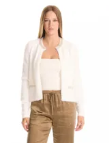 Chaqueta corta de tejido tipo mohair en color blanco, con cuello a la base decorado con bordado de perlas y canutillos. Presenta bolsillos simulados en el frente con apliques de brillos y cierre mediante broche interno.