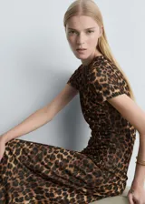 Vestido largo de tejido fluido con estampado de leopardo, cuello redondo y mangas cortas. Presenta un diseño entallado con detalles fruncidos en los laterales.