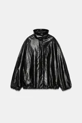Chaqueta tipo bomber de efecto cuero brillante, con cuello alto, manga larga con puños elásticos y cierre frontal con cremallera y botones ocultos bajo solapa. Cuenta con bolsillos delanteros y bajo ajustable con cordón elástico.