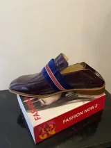 Mocasín de charol color borgoña con banda de terciopelo azul y ribete rojo.