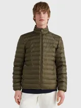 Campera acolchada verde oliva de poliéster reciclado, repelente al agua y plegable. Tiene cierre de cremallera, cuello alto con detalle de la bandera de la marca y logo bordado en el pecho.
