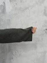 Polera de punto acanalado en color verde oliva, con cuello alto abierto lateralmente y mangas largas amplias. Presenta un diseño de corte recto y holgado.