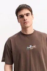 Remera oversize de algodón color marrón, de corte amplio y relajado, con estampa en el frente.