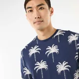 Remera azul marino de manga corta con estampado integral de palmeras blancas.