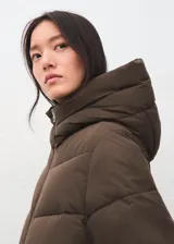 Parka acolchada color marrón chocolate, con diseño puffer, capucha integrada, cierre frontal y bolsillos laterales.