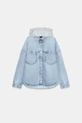 Cazadora de denim oversize con capucha gris desmontable, cuello camisero, cierre frontal con botones metálicos y bolsillos delanteros de plastrón.