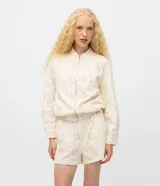 Campera bomber de sarga color beige con textura de laise floral, cuello alto, cierre frontal con cremallera y ruedo elástico.