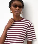 Remera oversized de algodón con rayas horizontales blancas y bordó, cuello redondo y mangas cortas.