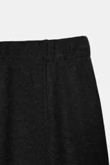 Pantalón de tiro alto con pierna ancha y cintura elástica ajustable. Presenta un diseño de corte holgado con costuras verticales frontales que definen su silueta.