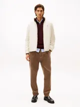 Campera ligera color crema, con cuello alto y cierre frontal de cremallera. Presenta un pequeño logo bordado de Tommy Hilfiger en el pecho.