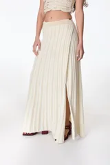 Falda larga color crema con lurex dorado, de tejido de punto acanalado y corte recto con abertura lateral.
