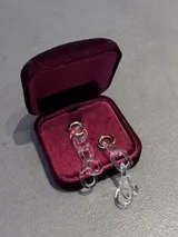 Aros colgantes de diseño maxi estilo cadena, compuestos por eslabones de vidrio transparente y argollas superiores en tono dorado.