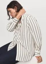 Camisa fluida de corte recto con diseño de rayas verticales, cuello camisero, manga larga y cierre frontal de botones.