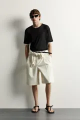 Remera relaxed fit confeccionada en tejido ligero de lyocell, de color negro con cuello redondo, manga corta y acabados en efecto doble combinado a contraste en color blanco.