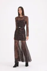 Vestido largo de tul transparente con estampado paisley en tonos chocolate y negro, de manga larga y cuello redondo. Incluye un forro interior tipo vestido corto y un cinturón fino negro con hebilla dorada.