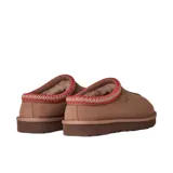 Pantuflas UGG modelo Tasman II, confeccionadas en gamuza color tostado. Presentan un diseño sin cordones con detalle de trenza decorativa en el borde superior y suela de goma resistente.