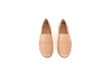 Mocasines de cuero color nude, con diseño clásico de calce fácil, costuras pespunteadas en la puntera y suela plana con leve tacón.