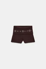 Shorts de algodón color marrón oscuro, con cintura elástica de tiro medio y detalle de rib con tachas metálicas decorativas.