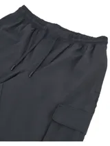 Pantalón cargo deportivo Under Armour Vibe Woven de color negro, con cintura elástica, bolsillos laterales amplios con solapa y puños elastizados en los tobillos. Confeccionado con tejido elástico y liviano con tecnología UA Storm que repele el agua.