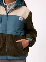 Campera con capucha de diseño combinado en bloques de color. Presenta una sección superior en pana rosada, una franja central en nylon marrón con logo de la marca y cuerpo inferior y mangas en tejido sherpa color crema. Incluye cierre frontal y bolsillos laterales.