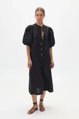 Vestido midi de lino negro, con cuello mao, mangas abullonadas hasta el codo y cierre frontal de botones de nácar.