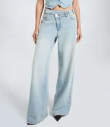 Pantalón wide leg de tiro medio confeccionado en denim de algodón. Presenta un diseño de cintura cruzada con cierre tradicional, trabillas para cinturón y bolsillos funcionales.