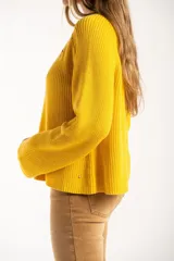 Sweater de punto en color amarillo, con diseño oversize, cuello redondo y manga larga. Presenta un pequeño bordado de un velero en la parte superior del pecho.