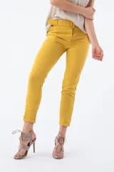 Pantalón de vestir color mostaza, con corte cigarette, cinturón con hebilla forrada y ruedo con dobladillo.
