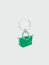 Llavero metálico con argolla grabada con el logo de la marca y dije en forma de bolso Le Pliage esmaltado en color verde.