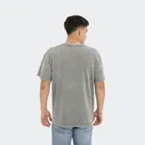 Remera verde oliva de corte oversize, con bolsillo en el pecho y logo de la marca.