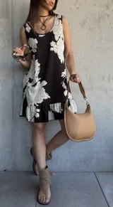 Vestido corto negro con estampado floral blanco, de corte suelto y sin mangas.