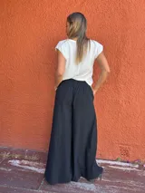Pantalón negro de corte palazzo, con cintura elástica en la parte trasera.