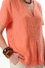 Blusa de lino color verde lima, con escote en V, mangas cortas y detalle de pliegue frontal.