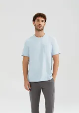 Remera celeste de manga corta con cuello redondo y bolsillo aplicado en el pecho.