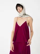 Top de terciopelo fucsia con breteles finos regulables y escote en V con detalle de encaje blanco. Silueta amplia y corte holgado.