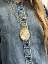 Collar con dije ovalado de bronce y centro de guampa, con cadena de eslabones de bronce.