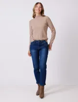 Jean azul de calce semi-ajustado, estilo Mom Slim, de tiro alto, relajado en la cadera y muslos, con pierna que se angosta levemente hacia el tobillo. Tiene pretina clásica con pasadores para cinturón, cierre frontal con cremallera y botón metálico, y bolsillos delanteros y traseros.