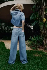Camisa de denim de corte recto y manga corta, con cuello solapa, cierre frontal con cremallera y dos bolsillos delanteros de plastrón.