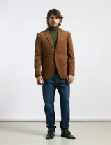 Saco sport de pana color marrón, con cuello con solapa, cierre frontal de dos botones y bolsillos laterales con tapa.