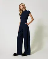 Pantalón de vestir azul marino con raya diplomática e hilo de lurex, corte palazzo, trabillas para cinturón, cierre con gancho y cremallera ocultos, pinzas delanteras, bolsillos diagonales en los laterales y bolsillos de ribete en la parte trasera, placa con el logo Oval T en la parte trasera.