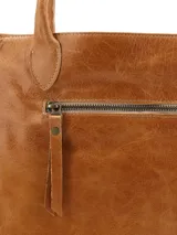 Cartera shopper Hush Puppies de cuero color tostado con doble asa de hombro y borlas decorativas colgantes en los laterales.