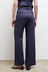 Pantalón de vestir color beige, de corte recto y tiro alto, confeccionado en lino 100% con bolsillos laterales.