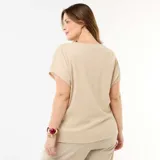 Camisa de manga corta color beige, con escote en V y cierre frontal de botones estampados. Corte holgado y ligero.