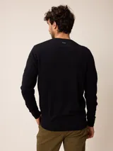 Sweater de punto con cuello redondo, manga larga y puños acanalados. Presenta un pequeño logo bordado en el pecho.