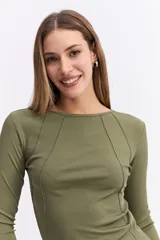 Remera de manga larga color beige, con ajuste al cuerpo y costuras decorativas visibles en el frente que realzan la silueta.