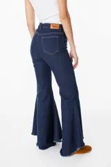 Jean elastizado azul oscuro con diseño de volados en la parte baja de la pierna, ruedo descosido con juego de largos (más largo atrás que adelante).