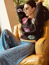 Sweater tejido artesanalmente en lana color negro, con apliques de corazones hechos a mano en crochet.